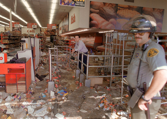 Mike Nelson/AFP/Getty Images A store owner and a Los Angeles Police Department officer look at the damage caused by looters on April 1992, in Los Angeles.